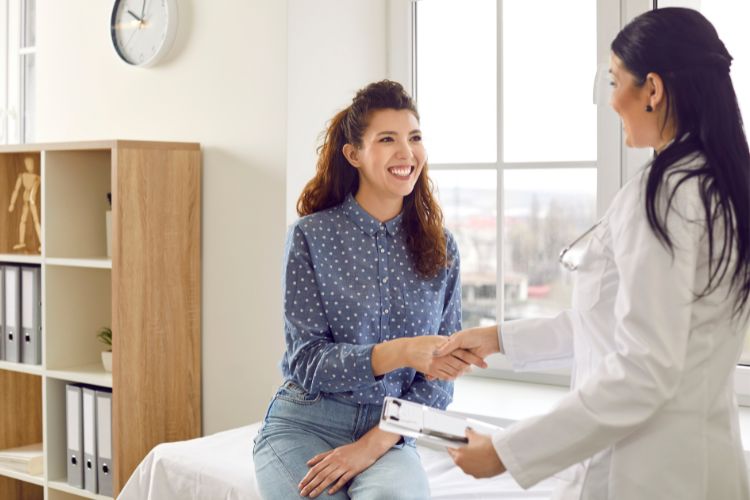 Smiling woman shaking hands with doctor